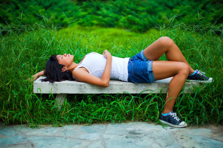 Young woman relaxing on the bench in the park