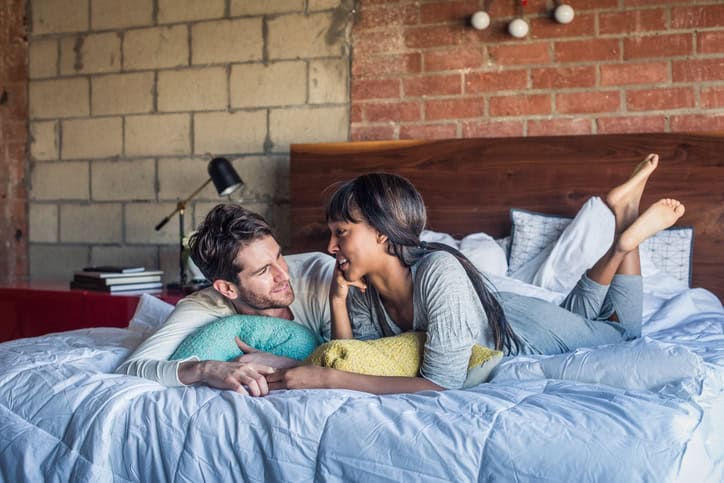 Multi Ethnic Couple in Bed Engaged in Pillow talk