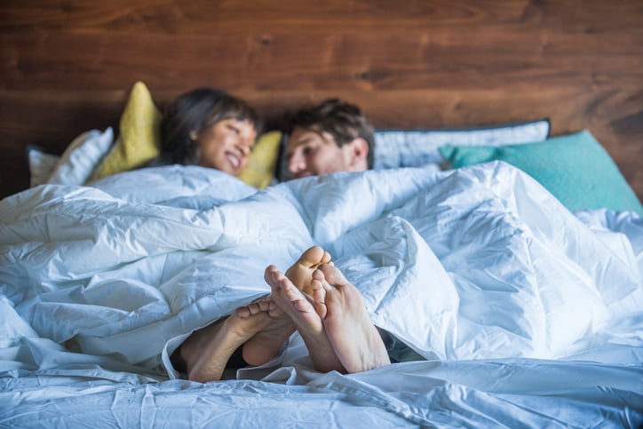 Multi Ethnic Couple in Bed being playful