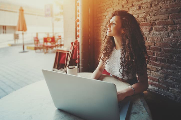 Curly girl with laptop in cafe