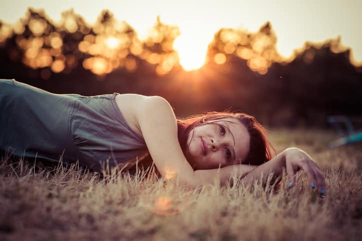 Woman lying in grass and enjoying the sunset