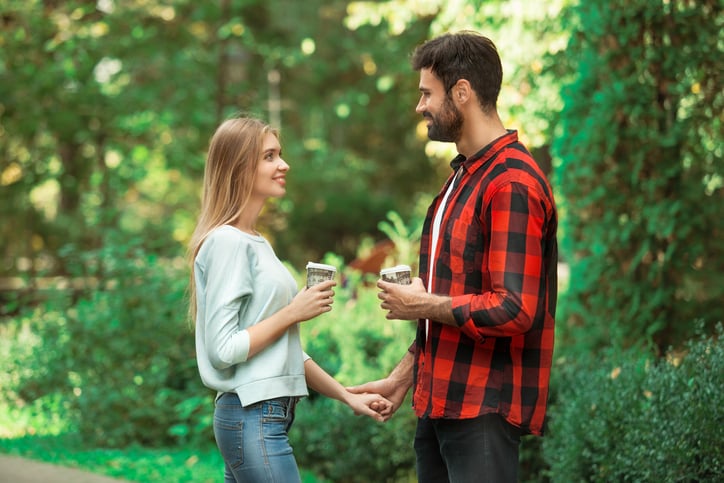 Young couple woman and man walking outdoors holding hands