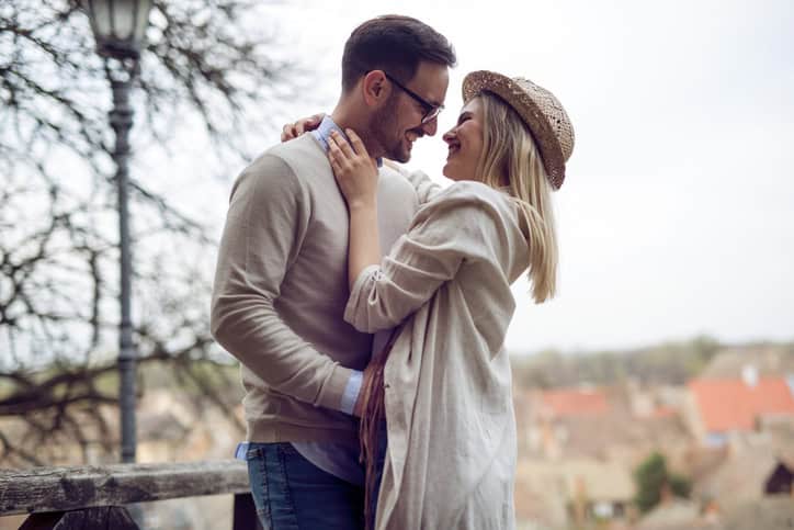 Happy couple in love hugging and smiling outdoor
