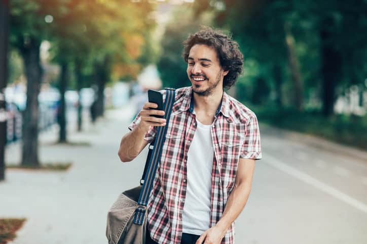 curly haired man texting