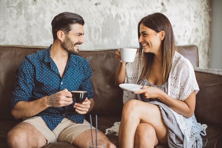 Smiling Italian couple sitting together at a cafe.