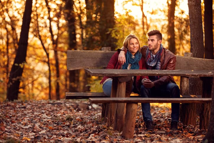 love in the autumn park- Romantic couple on bench