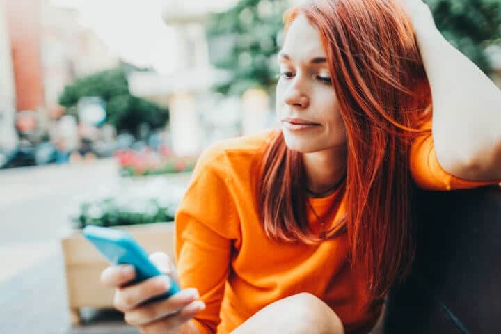 Woman using a smart phone outdoors in the city.
