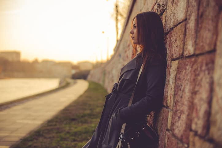 Street styled woman leaning on the wall at the river jetty