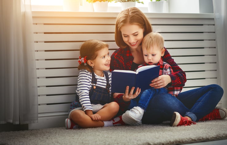 Mother reads book to children son and daughter