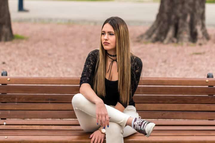 Unhappy girl sitting at bench
