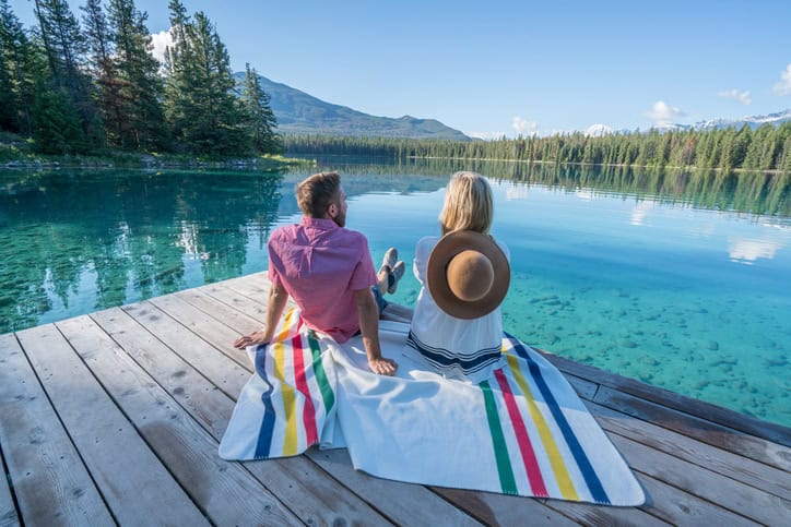 Young adults relaxing on lake pier in the morning