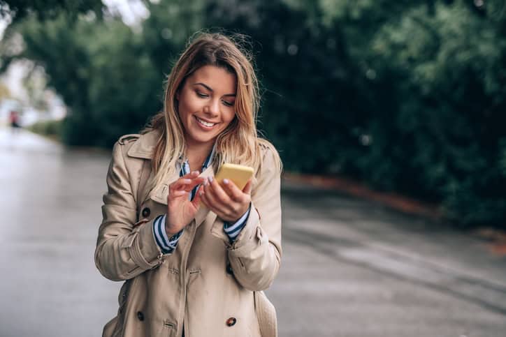 Attractive woman texting on the phone in the city.