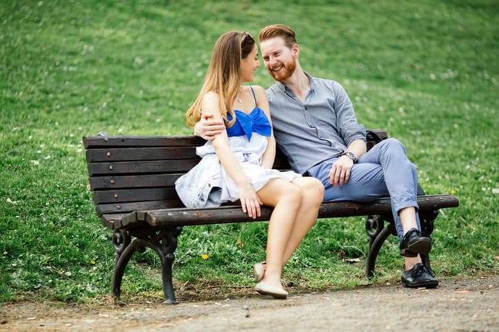 Couple in love spending time in nature on park bench