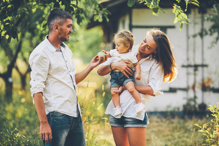 Parents with a child in the summer garden.