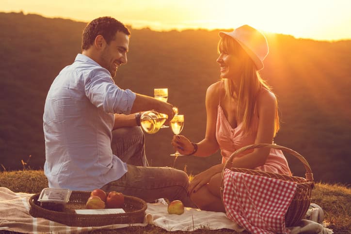 Smiling man at sunset pouring wine