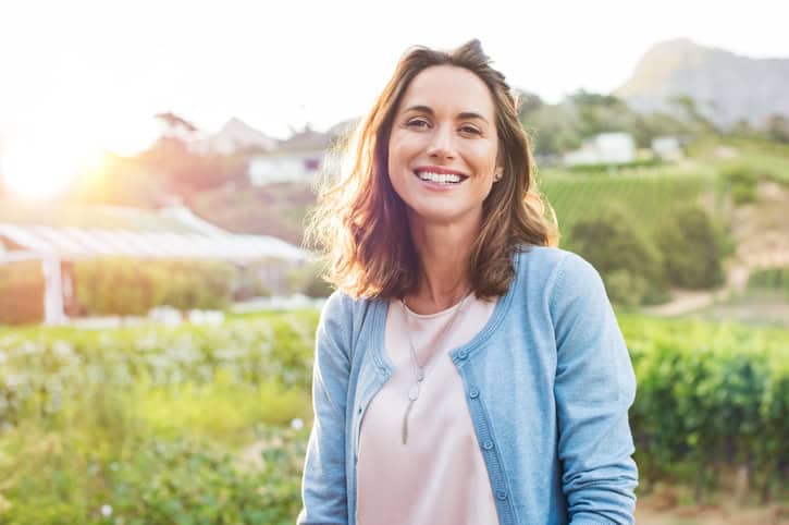 smilng brunette woman outside
