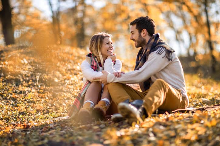 Smiling couple talking while enjoying in their love outdoors.