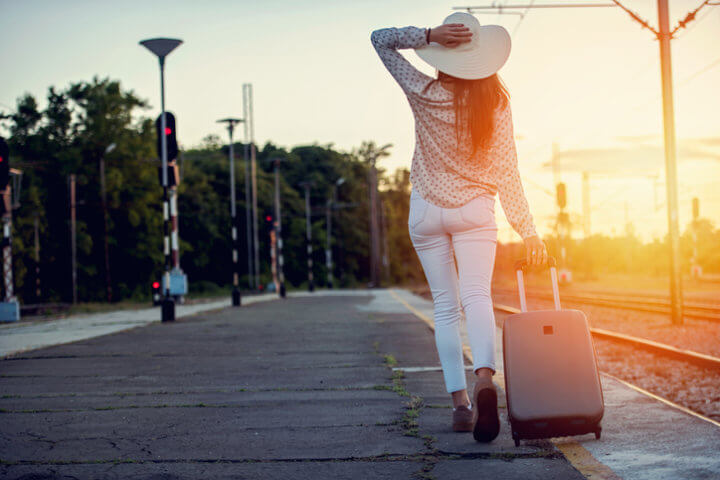 Young woman with luggage at the train station.