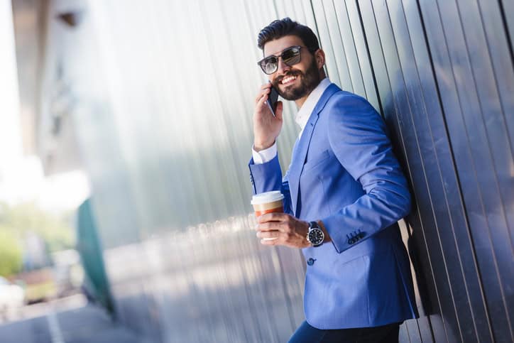 Handsome business man talking on phone and checking email