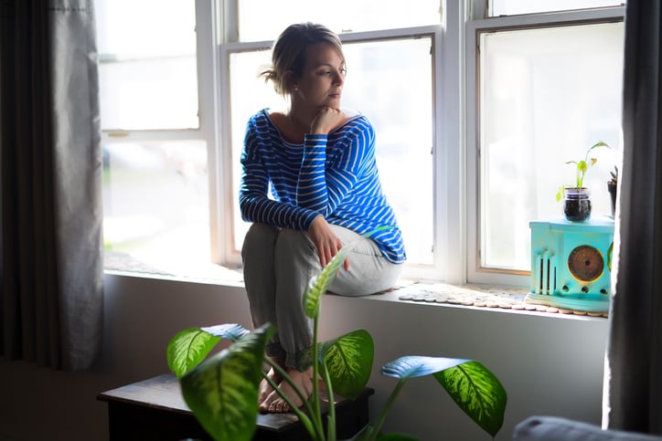 A Beautiful young woman sitting near window