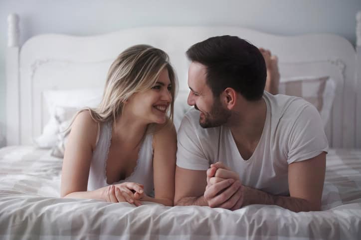 Beautiful woman and attractive man lying on bed together