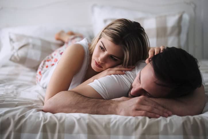 Beautiful young woman lying with her handsome boyfriend on bed