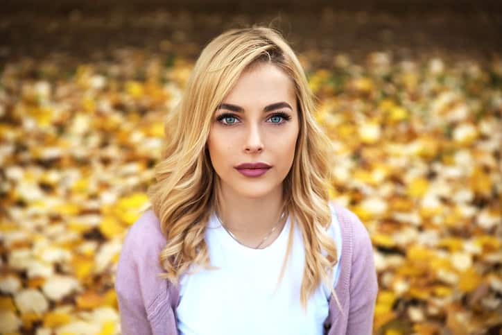 Portrait of beautiful blonde girl sitting in park