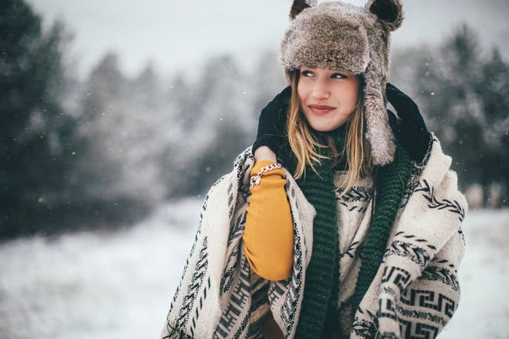 Cute woman with fur hat on snowy day in nature