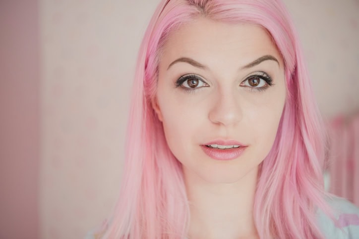 Portrait of young woman with dyed pink hair and pensive expression