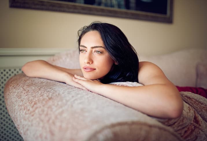 Young woman is lying on the sofa in the morning and dreaming