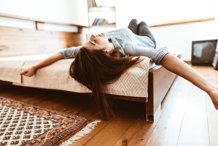Woman laying on the bed as if dead.