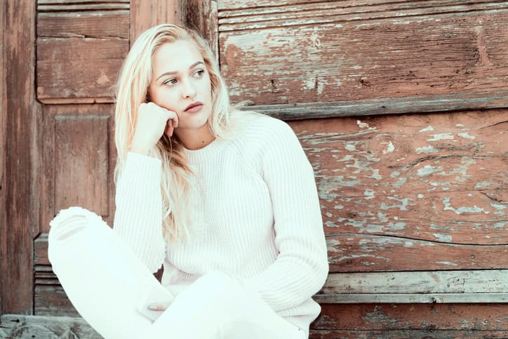 Girl in depression is standing sad on the home stairs