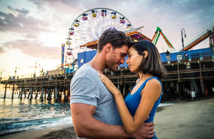 Couple of lovers on a romantic date at the beach at sunset