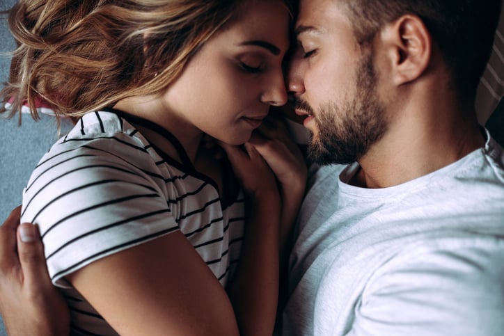 young couple in bed embracing