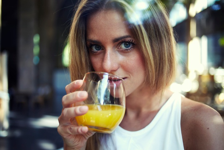 Woman enjoying the glass of orange juice.