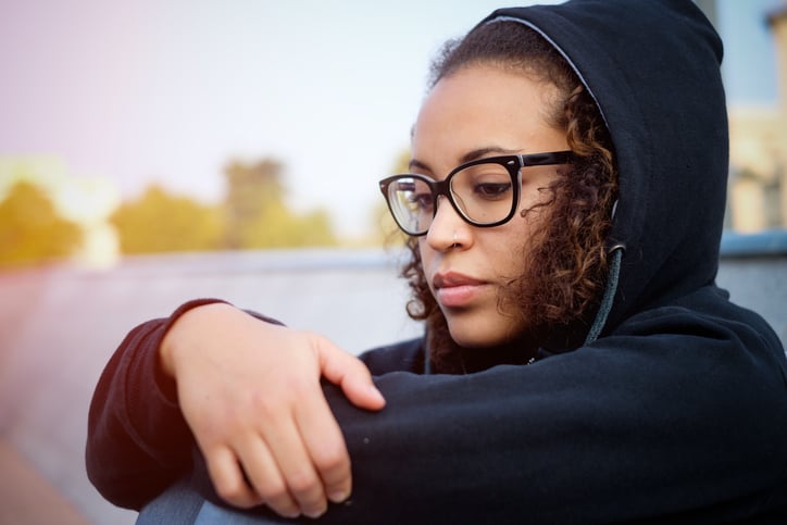 Sad young afro-american girl alone in the city street