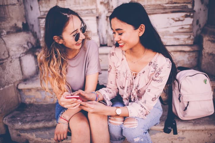 Two asian girls texting