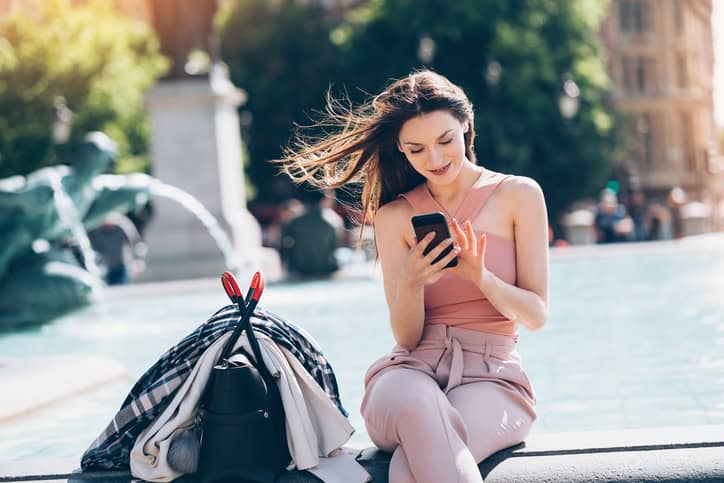 Young woman texting outdoors in the city.