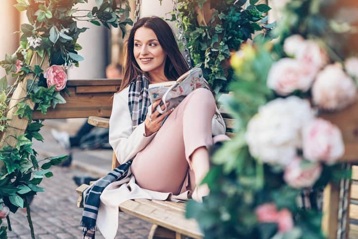 Beautiful young woman relaxing with a book outdoors