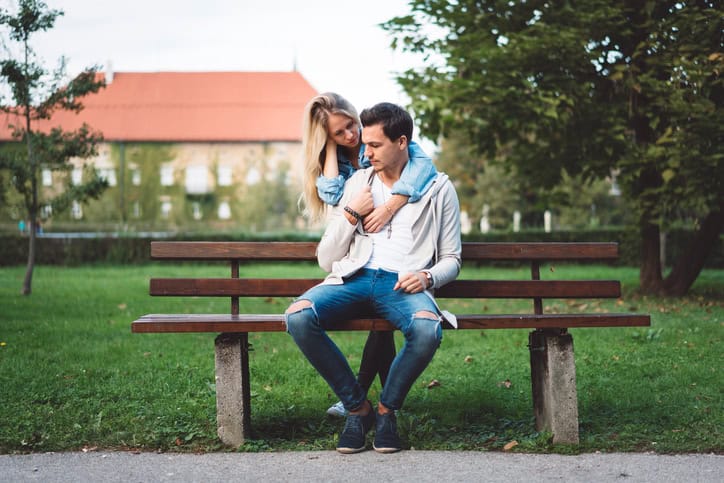 Young woman and man hugging, lost in their thoughts