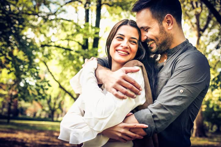 Young couple in hug standing in nature.