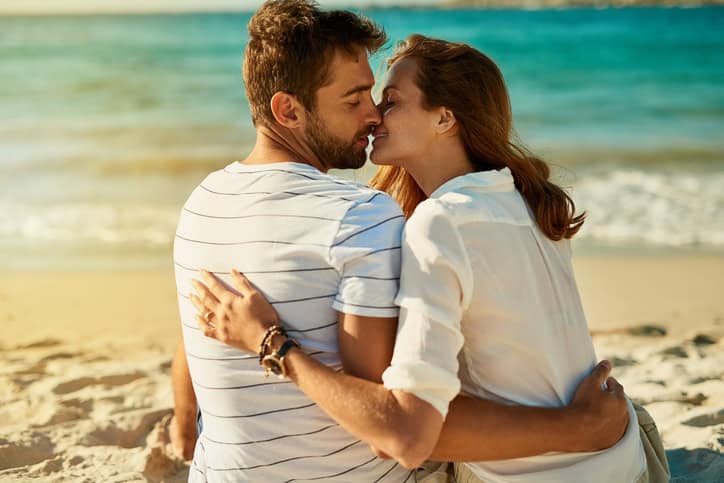 Shot of a young couple kissing on a summer’s day at the beach