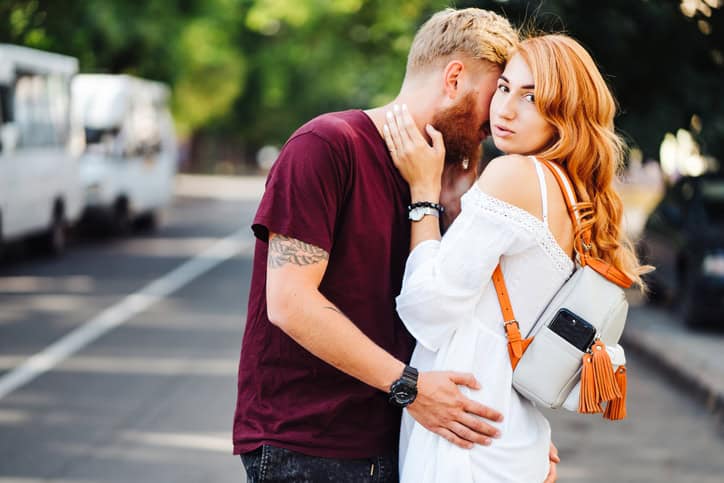 beautiful couple posing outdoors at the camera