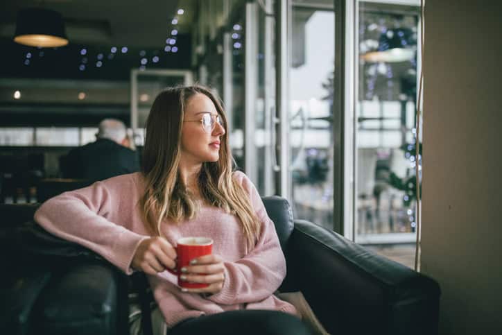 woman with glasses looking out of window