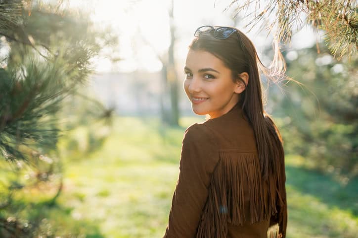 young brunette woman smiling outside