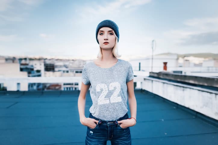 young woman is posing on a rooftop wearing street urban style outfit