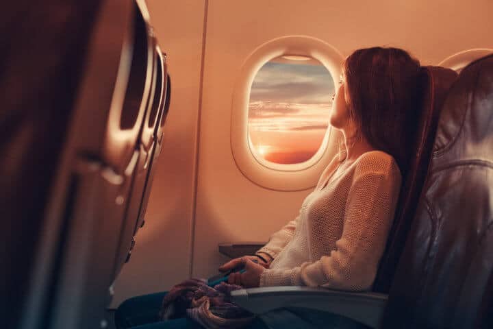 Woman on airplane looking through the window.