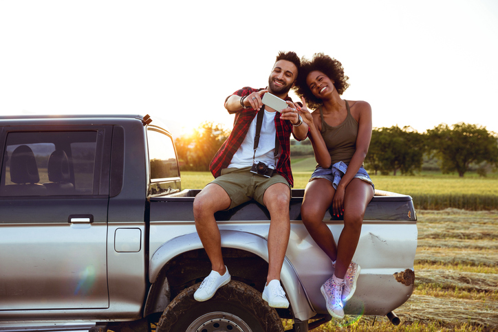 Man and wife on the back of a car.