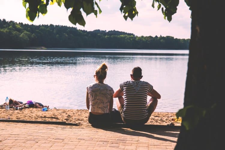 couple sitting by trees