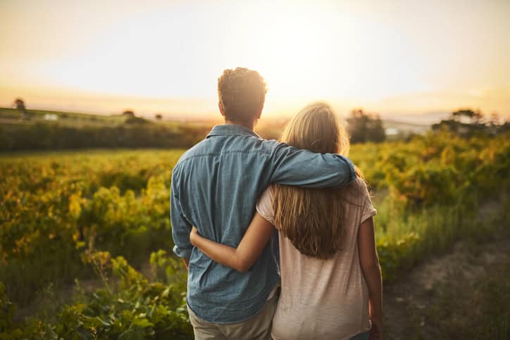 Couple walking in a meadow.